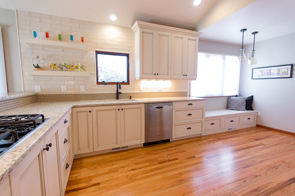 Transitional light wood floor and brown floor eat-in kitchen photo with an undermount sink, shaker cabinets, white cabinets, quartz countertops, white backsplash, ceramic backsplash and stainless steel appliances