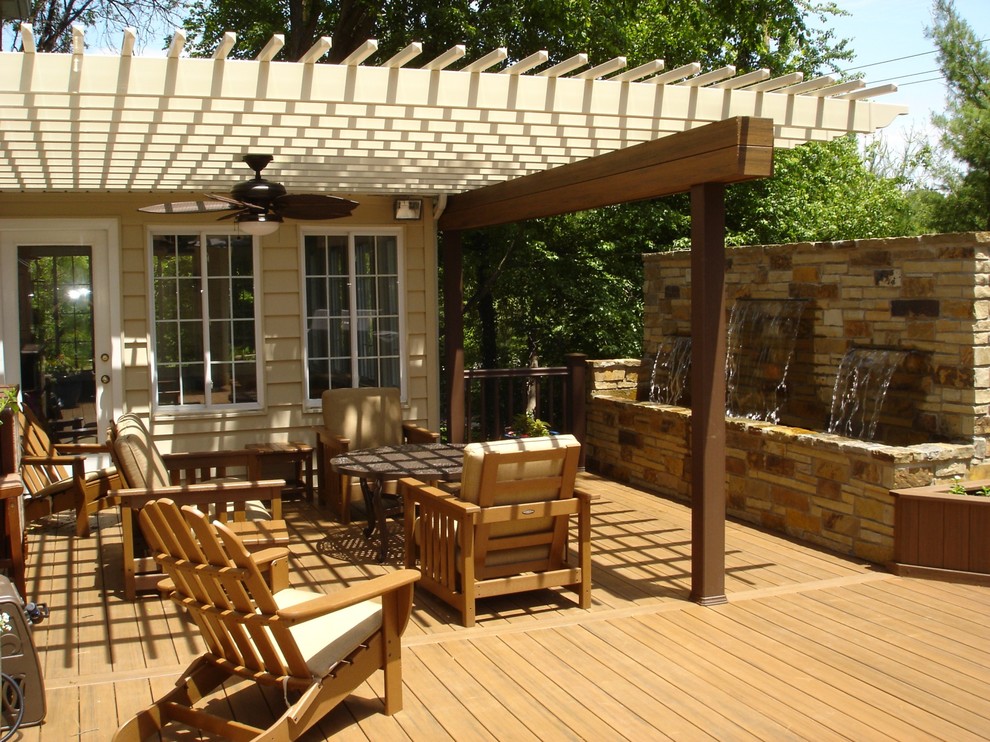 Example of a mid-sized backyard deck design in St Louis with a pergola