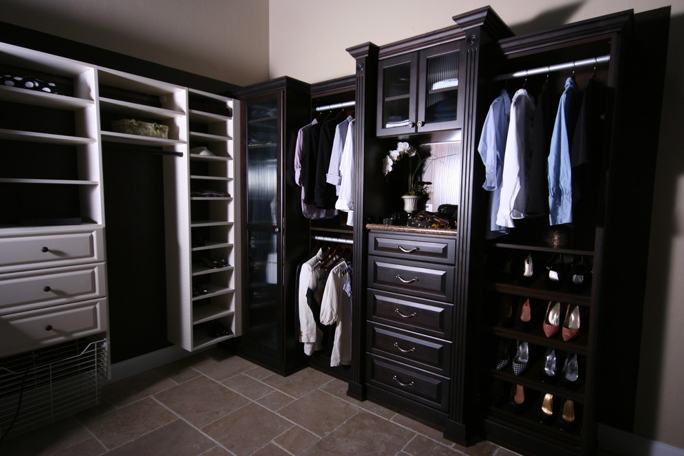 Traditional gender-neutral walk-in wardrobe in Miami with raised-panel cabinets, black cabinets and beige floor.