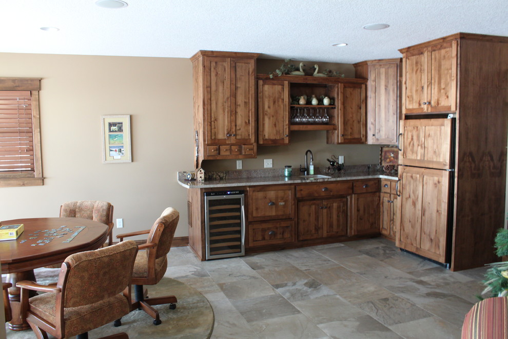 Photo of a small country l-shaped open plan kitchen in Minneapolis with an undermount sink, recessed-panel cabinets, dark wood cabinets, granite benchtops, panelled appliances and no island.