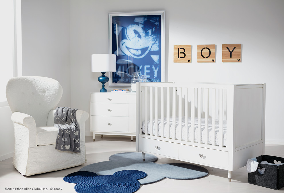 Photo of a mid-sized transitional nursery for boys in New York with white walls, painted wood floors and white floor.