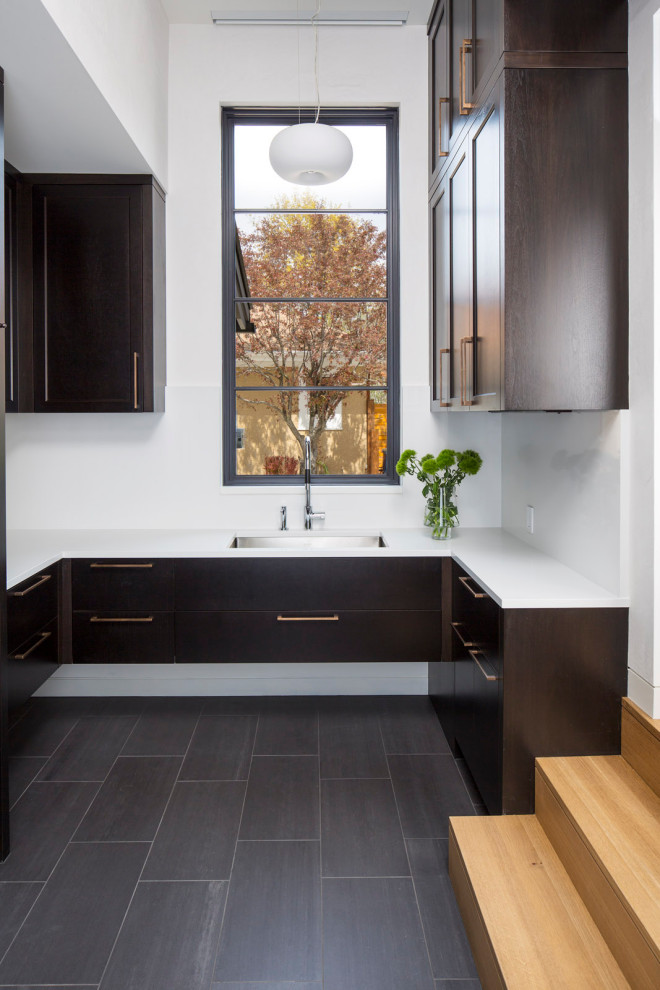 This is an example of a modern storage and wardrobe in Minneapolis with shaker cabinets, dark wood cabinets, ceramic floors and black floor.