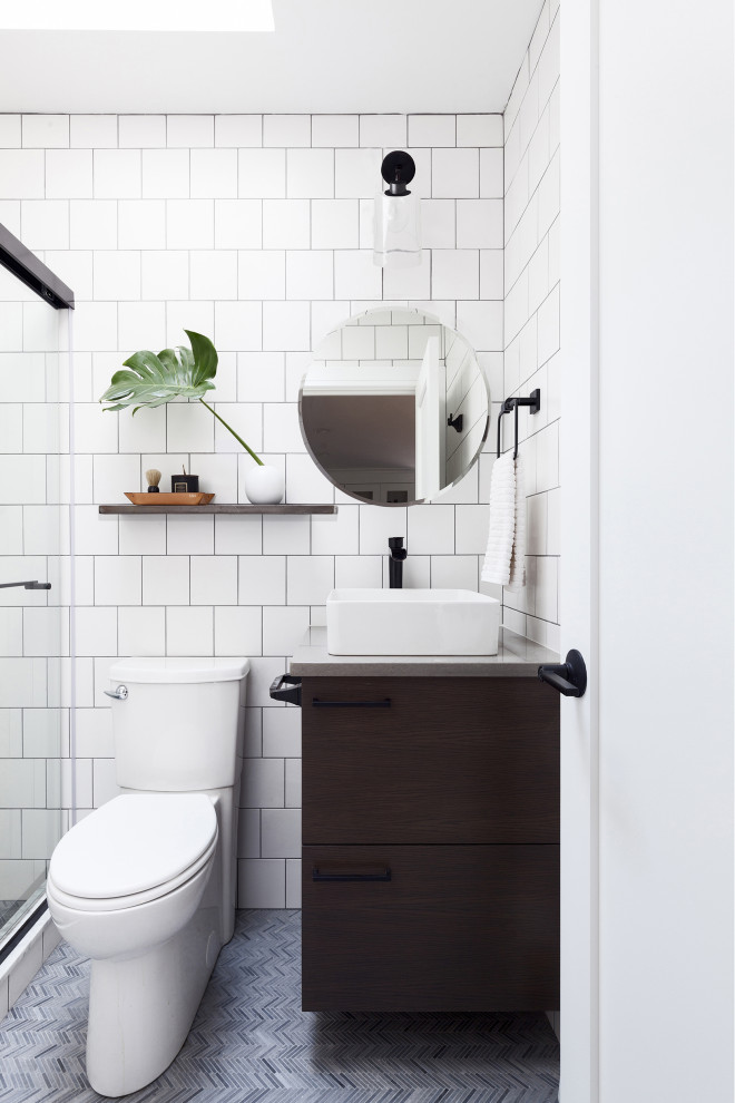 Photo of a contemporary 3/4 bathroom in New York with flat-panel cabinets, dark wood cabinets, a two-piece toilet, white tile, a vessel sink, grey floor, a sliding shower screen, grey benchtops, a single vanity and a built-in vanity.