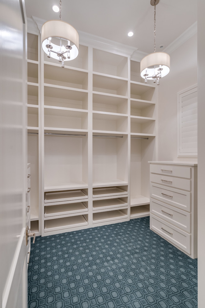 Photo of a large transitional gender-neutral walk-in wardrobe in Dallas with recessed-panel cabinets, white cabinets, carpet and blue floor.