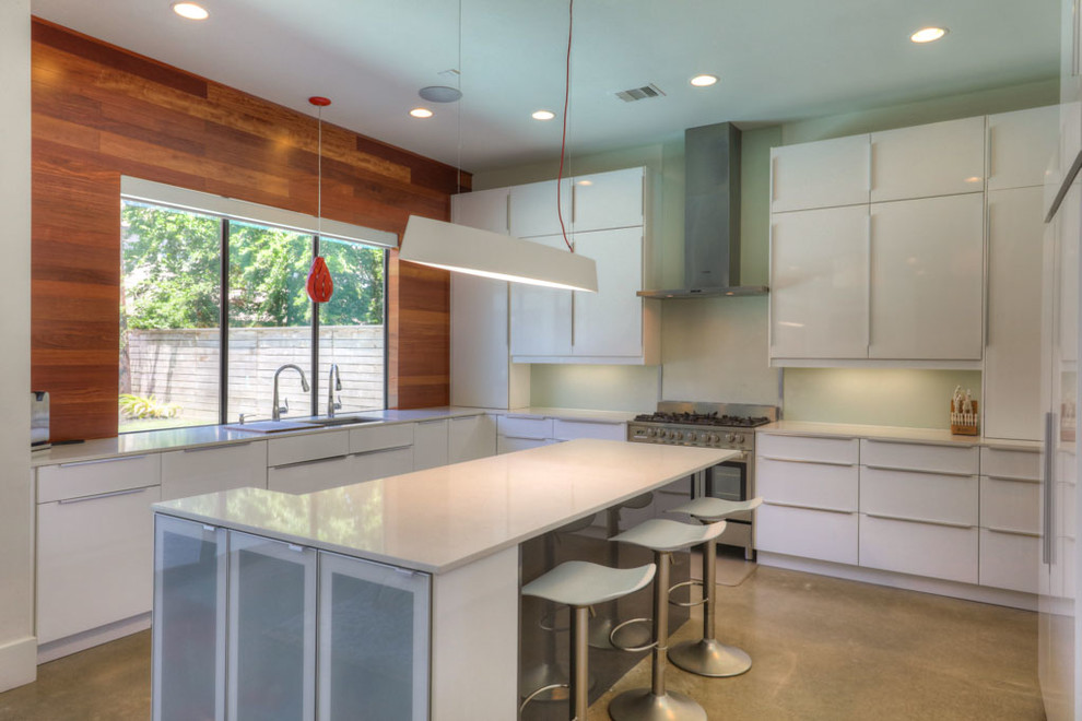 Design ideas for a large midcentury u-shaped eat-in kitchen in Houston with an undermount sink, flat-panel cabinets, white cabinets, quartz benchtops, white splashback, glass sheet splashback, stainless steel appliances, concrete floors, with island and grey floor.