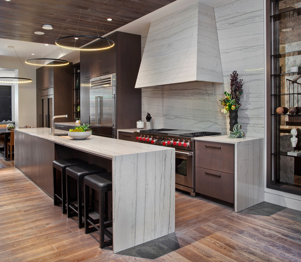 Inspiration for a large contemporary galley eat-in kitchen in Chicago with an undermount sink, flat-panel cabinets, dark wood cabinets, grey splashback, stone slab splashback, stainless steel appliances, dark hardwood floors and with island.