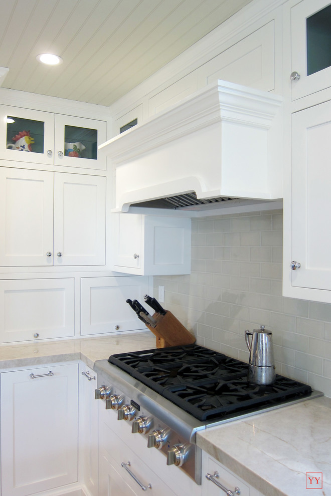 Example of a mid-sized transitional u-shaped light wood floor eat-in kitchen design in Los Angeles with shaker cabinets, white cabinets, quartzite countertops, beige backsplash, ceramic backsplash, stainless steel appliances, a double-bowl sink and an island
