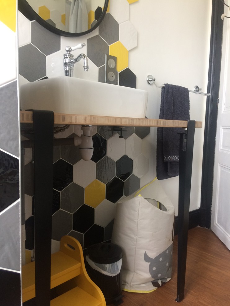 Inspiration for a medium sized retro ensuite bathroom with a claw-foot bath, a shower/bath combination, a wall mounted toilet, yellow tiles, bamboo flooring, a vessel sink, wooden worktops and white walls.