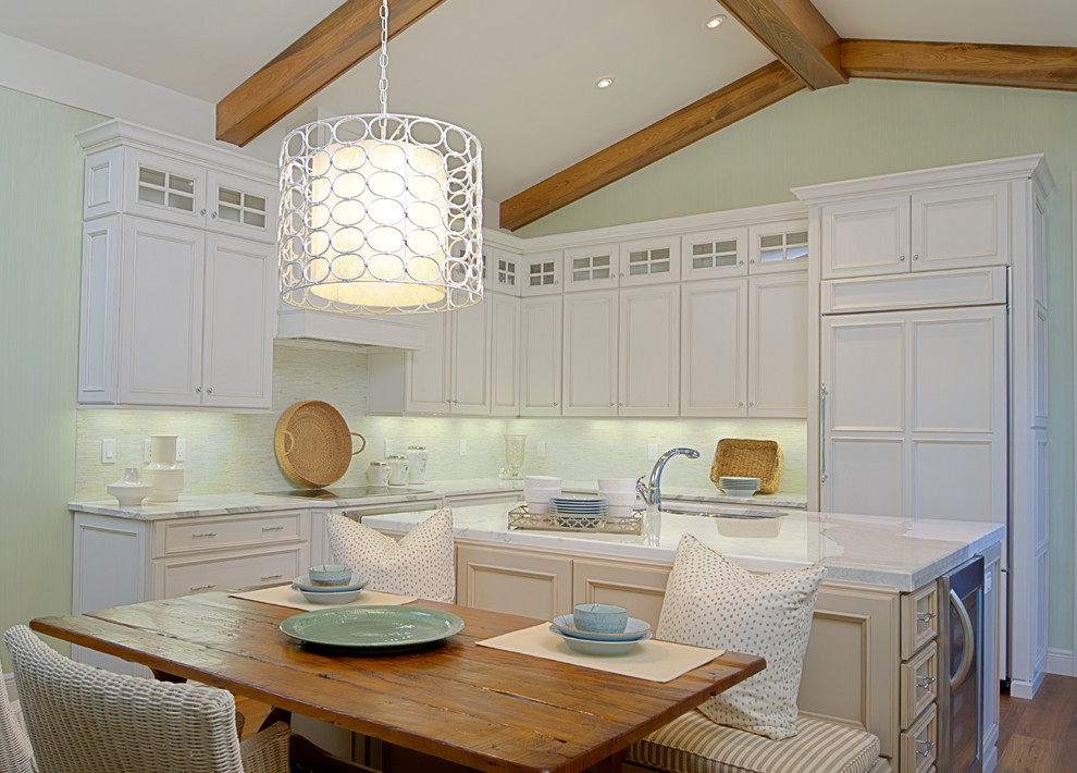 Design ideas for a traditional l-shaped eat-in kitchen in Orlando with recessed-panel cabinets, white cabinets, panelled appliances, white splashback, medium hardwood floors and with island.