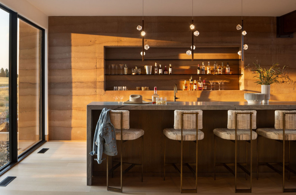 Large mountain style galley light wood floor wet bar photo with solid surface countertops and beige countertops