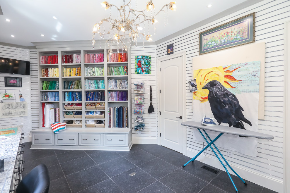 Photo of a large transitional craft room in Atlanta with white walls, porcelain floors, a built-in desk, black floor and panelled walls.