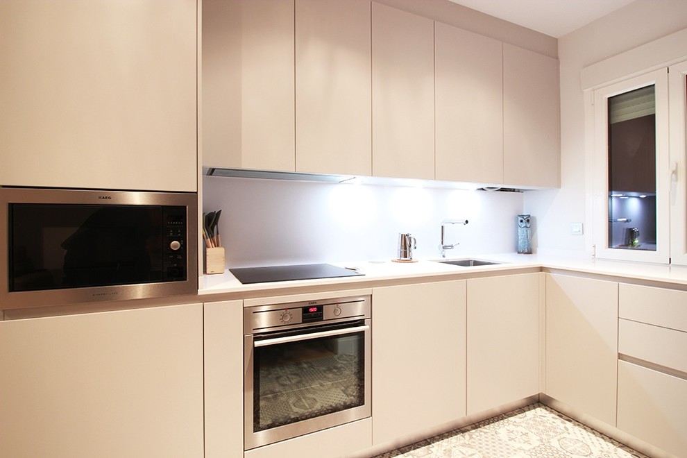 Mid-sized modern l-shaped eat-in kitchen in Madrid with an integrated sink, flat-panel cabinets, beige cabinets, quartz benchtops, beige splashback, ceramic floors and no island.