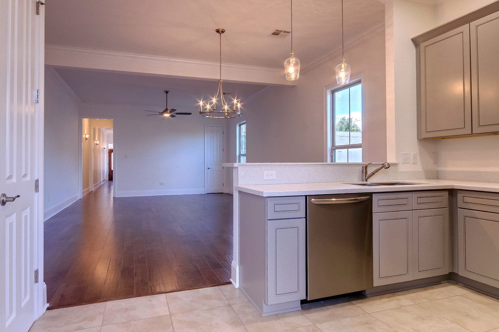 Photo of a small traditional u-shaped open plan kitchen in New Orleans with an undermount sink, raised-panel cabinets, grey cabinets, stainless steel appliances, ceramic floors and no island.