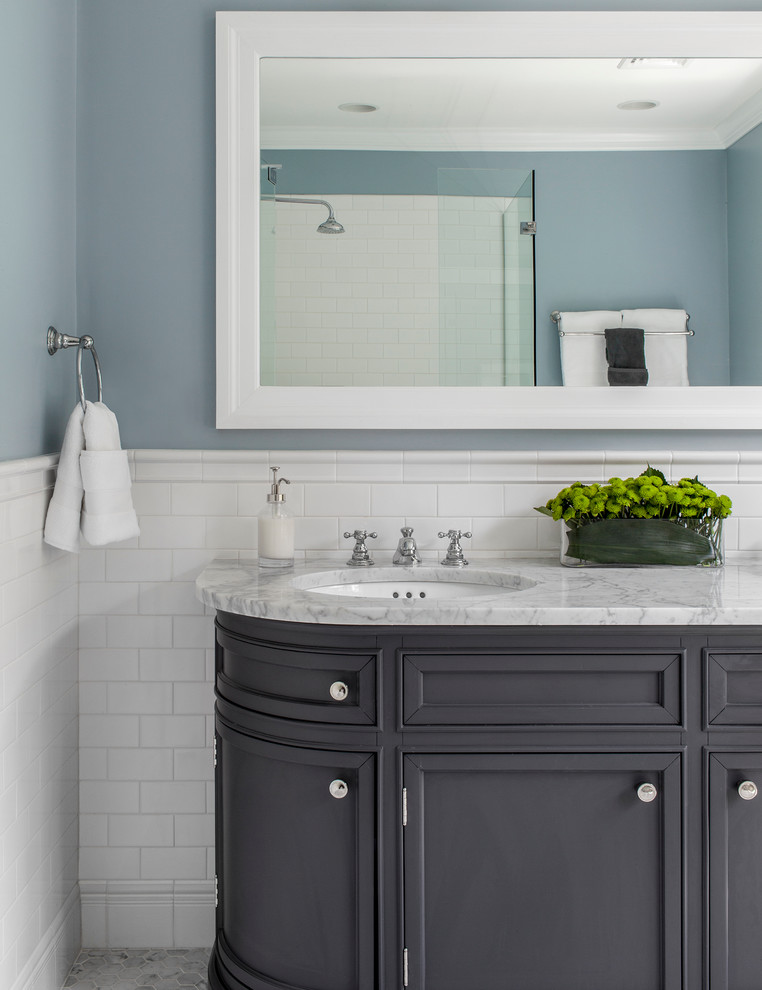 This is an example of a mid-sized traditional master bathroom in Boston with an undermount sink, recessed-panel cabinets, grey cabinets, marble benchtops, a corner shower, white tile, ceramic tile, blue walls and marble floors.