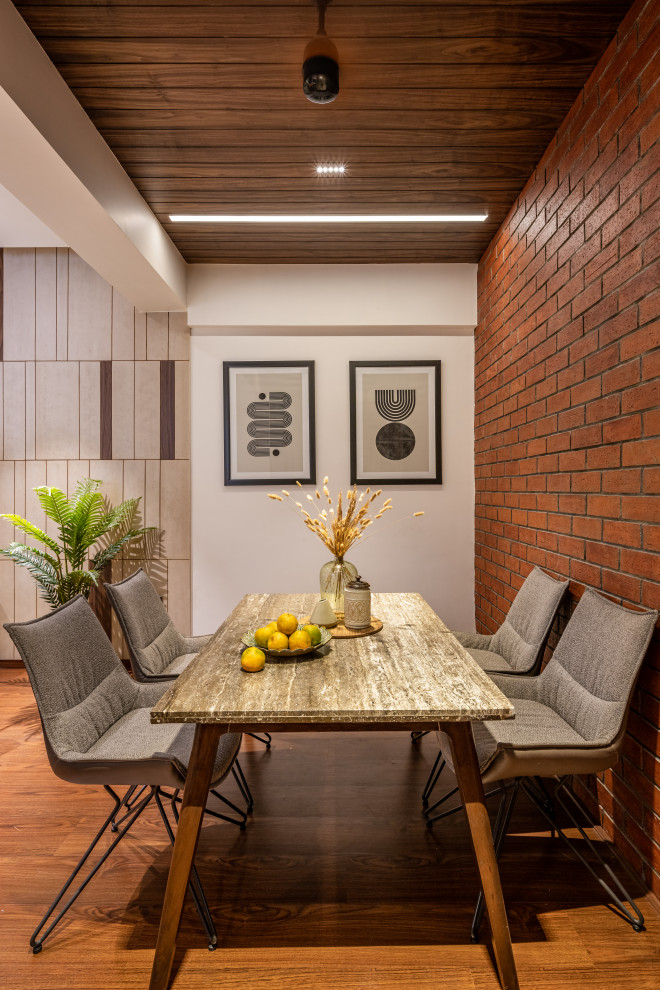 Immagine di una sala da pranzo moderna con pareti bianche, parquet chiaro, pavimento marrone e pareti in mattoni