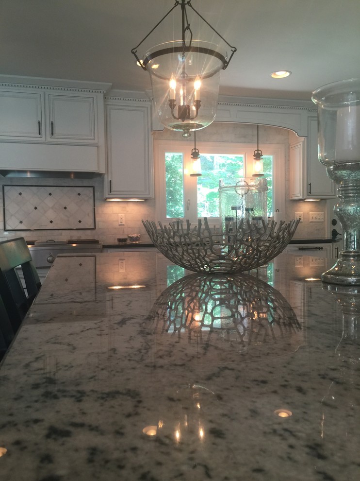 Inspiration for a large transitional l-shaped dark wood floor home design remodel in Baltimore with a farmhouse sink, flat-panel cabinets, white cabinets, granite countertops, white backsplash, stone tile backsplash, paneled appliances and an island
