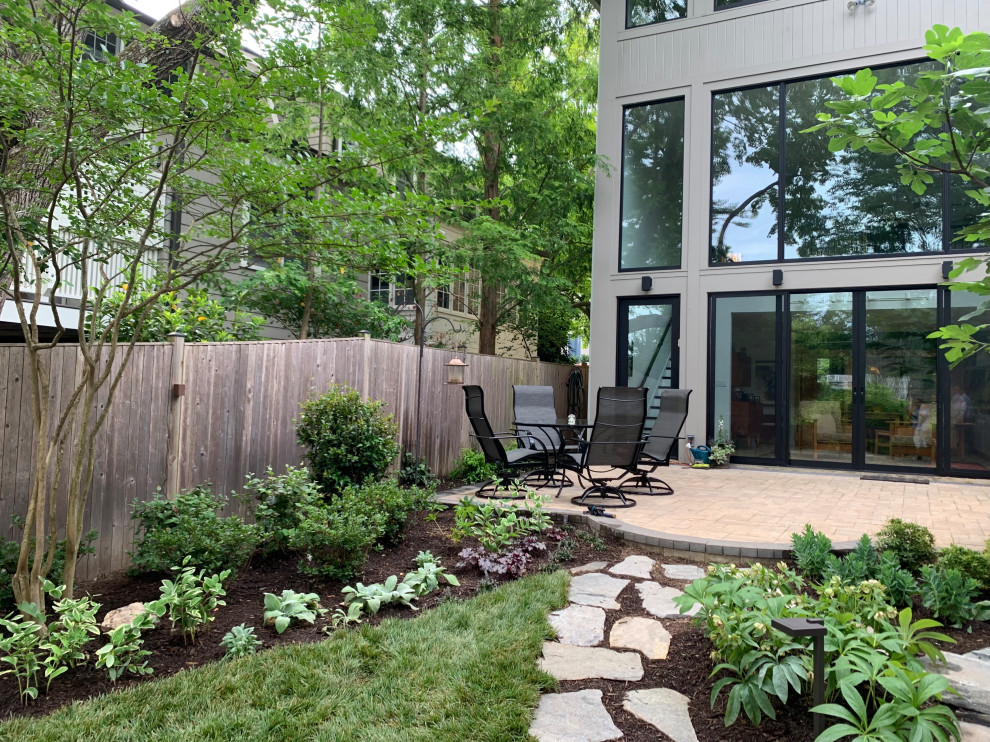 Photo of a transitional backyard patio in DC Metro with natural stone pavers.