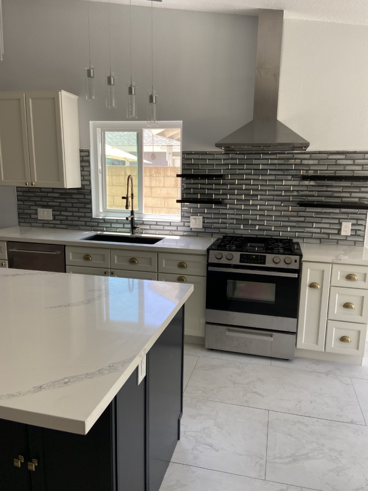 This is an example of a mid-sized transitional galley eat-in kitchen in Orange County with an undermount sink, shaker cabinets, white cabinets, quartzite benchtops, grey splashback, subway tile splashback, stainless steel appliances, marble floors, with island, white floor, white benchtop and vaulted.
