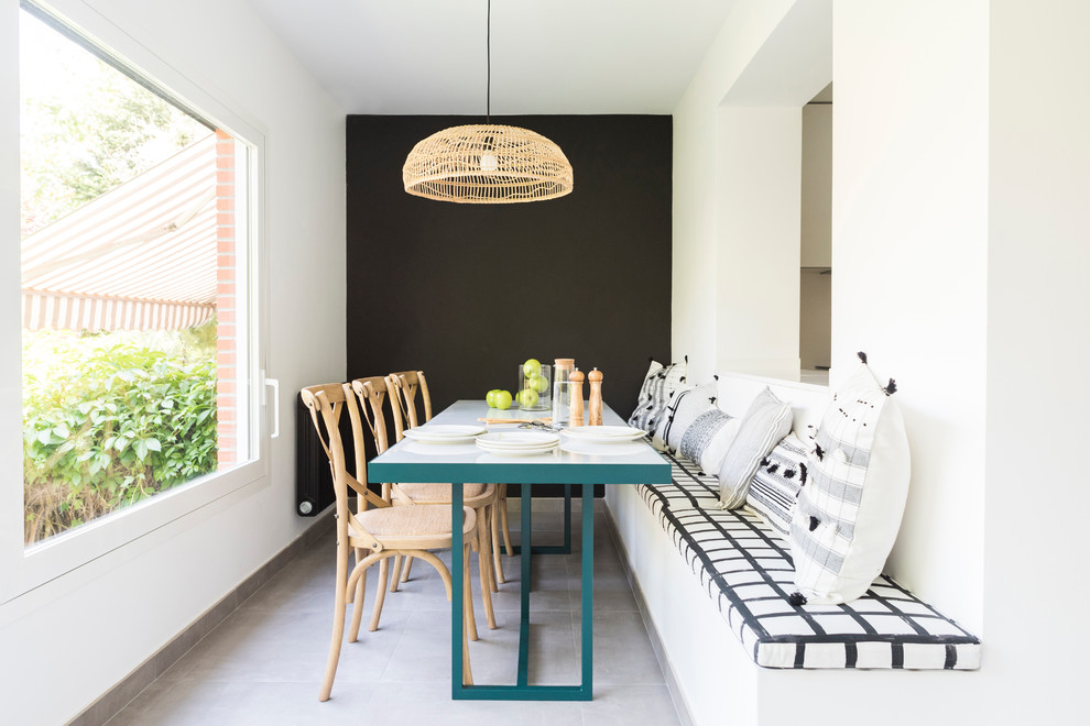 This is an example of a contemporary dining room in Madrid with white walls and grey floor.
