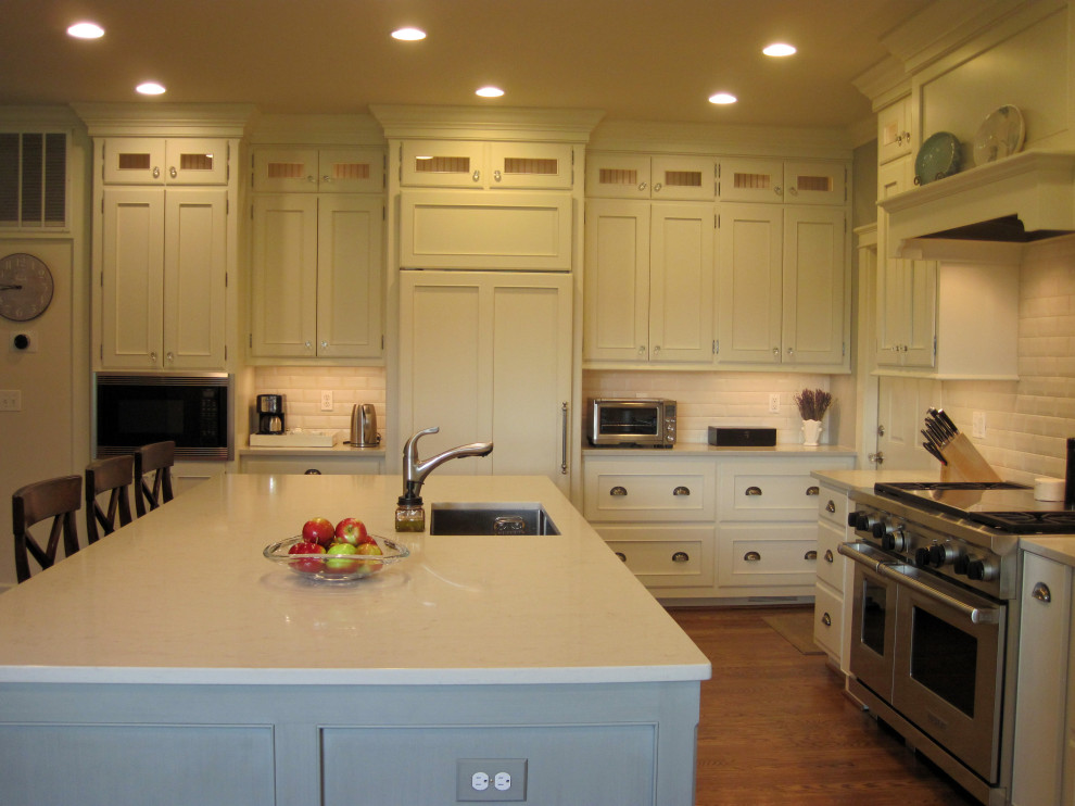 Example of a large transitional u-shaped medium tone wood floor eat-in kitchen design in DC Metro with an undermount sink, shaker cabinets, green cabinets, quartz countertops, subway tile backsplash, stainless steel appliances, an island and white countertops