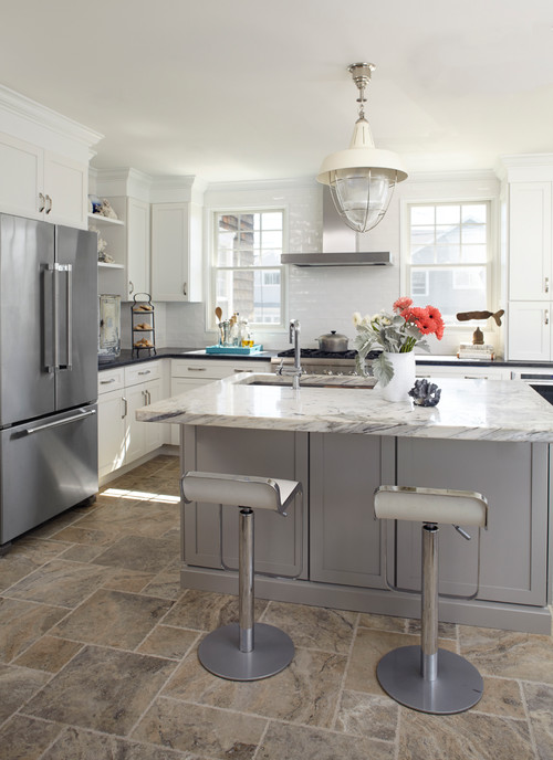 Modern kitchen featuring white upper kitchen cabinets, a grey island with seating, and a stainless steel French door refrigerator