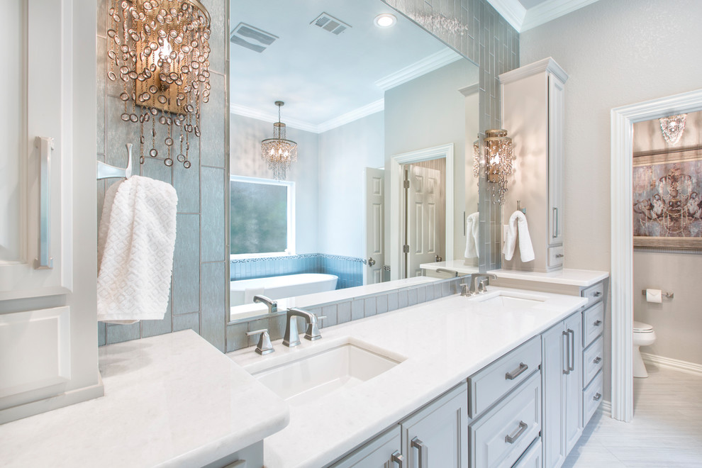 Inspiration for a large contemporary master bathroom in Other with raised-panel cabinets, grey cabinets, a freestanding tub, a corner shower, beige tile, glass tile, beige walls, an undermount sink, marble benchtops, beige floor and a hinged shower door.