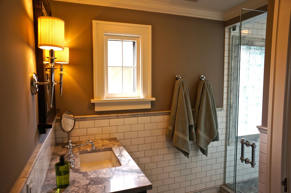 Design ideas for a mid-sized traditional master bathroom in Minneapolis with shaker cabinets, black cabinets, an open shower, a one-piece toilet, white tile, subway tile, grey walls, marble floors, an undermount sink and marble benchtops.