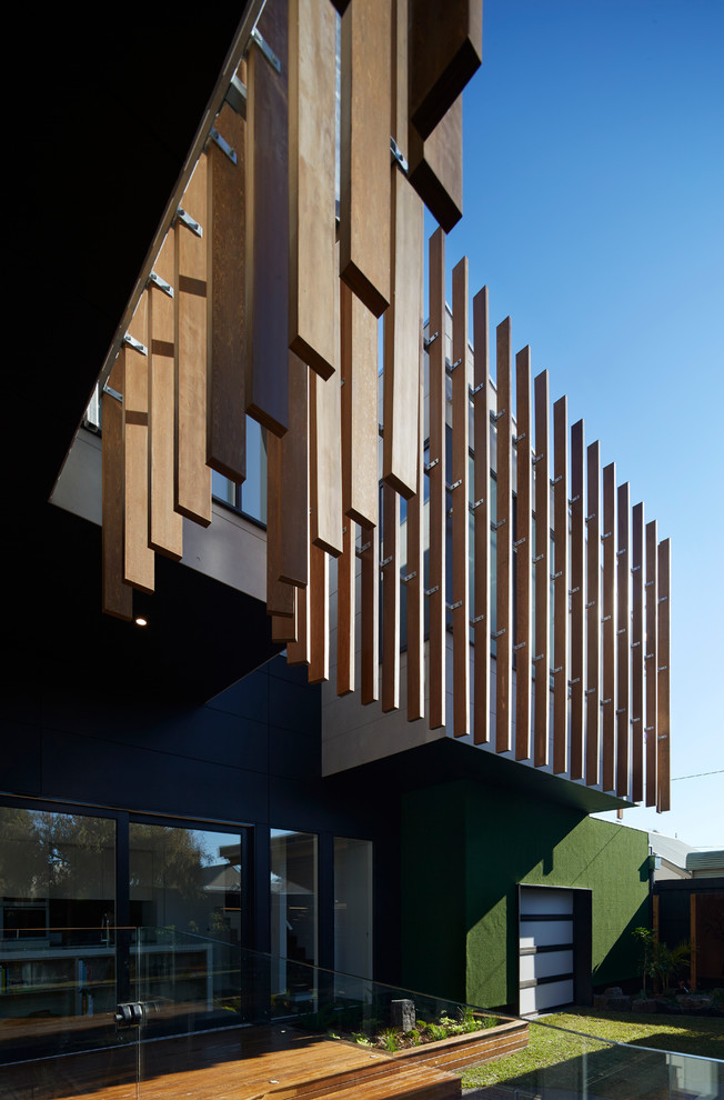 Contemporary two-storey black exterior in Melbourne with concrete fiberboard siding and a shed roof.
