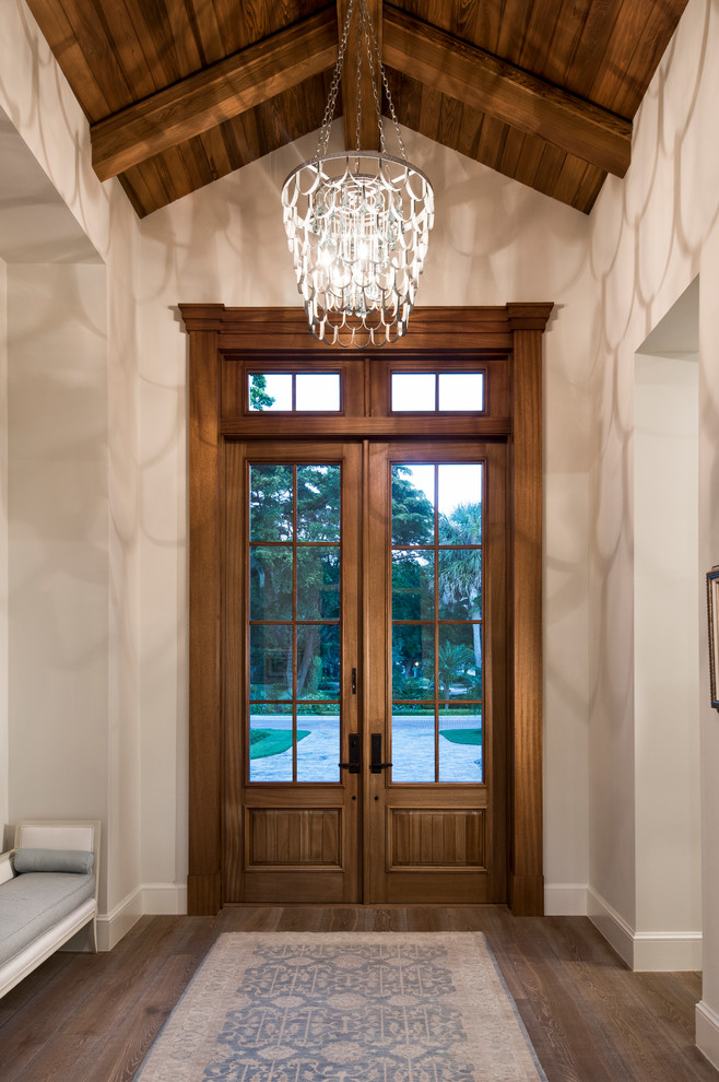 Photo of a country entryway in Miami with white walls, dark hardwood floors, a double front door, a dark wood front door and brown floor.