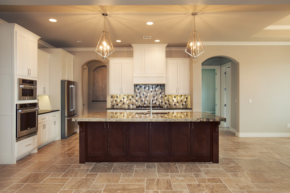 Open concept kitchen - mid-sized transitional l-shaped ceramic tile open concept kitchen idea with an undermount sink, shaker cabinets, white cabinets, granite countertops, multicolored backsplash, glass tile backsplash, stainless steel appliances and an island