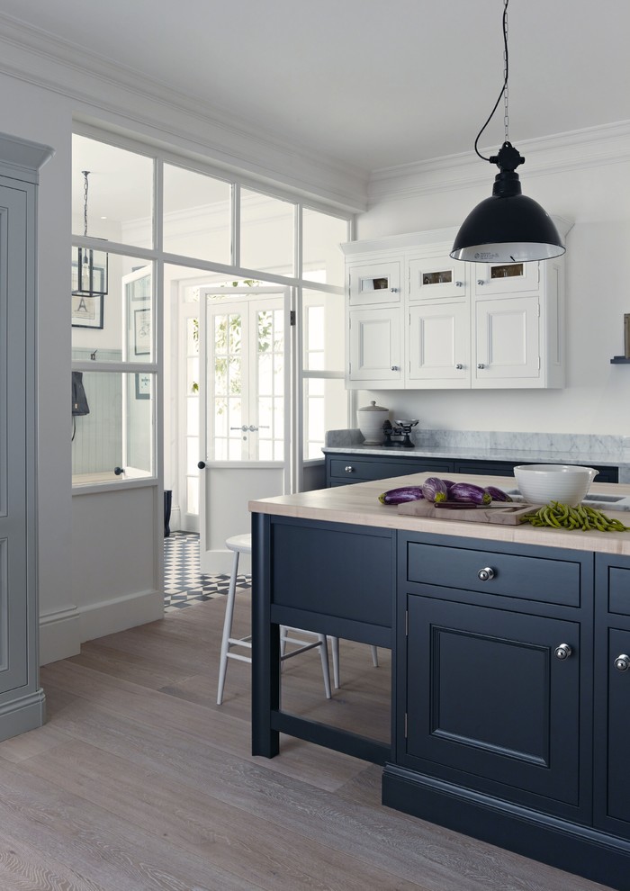 Inspiration for a medium sized traditional kitchen with beaded cabinets, green cabinets, wood worktops, marble splashback, light hardwood flooring, an island and brown floors.