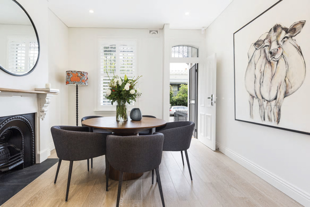 This is an example of a contemporary dining room in Sydney with beige walls, light hardwood floors and beige floor.