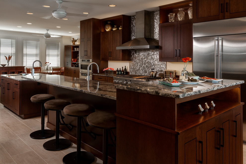 Large transitional galley porcelain tile kitchen pantry photo with an undermount sink, flat-panel cabinets, medium tone wood cabinets, quartz countertops, brown backsplash, stainless steel appliances and two islands