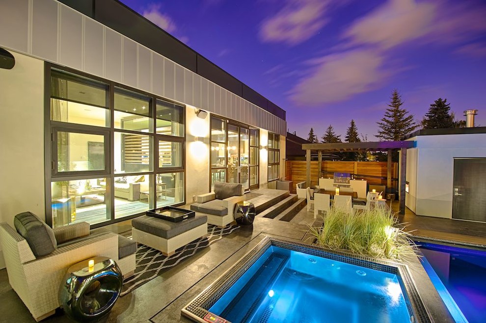 Inspiration for a contemporary backyard rectangular pool in Calgary with a hot tub.