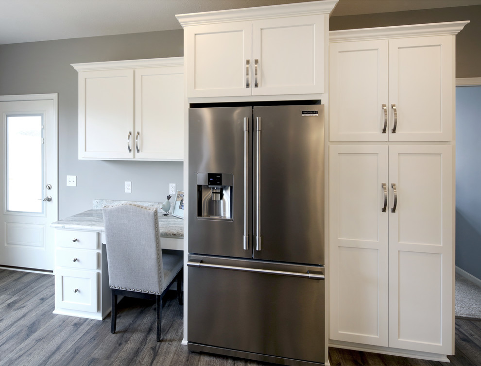 Transitional l-shaped gray floor eat-in kitchen photo with an undermount sink, white cabinets, stainless steel appliances, an island, recessed-panel cabinets and multicolored countertops
