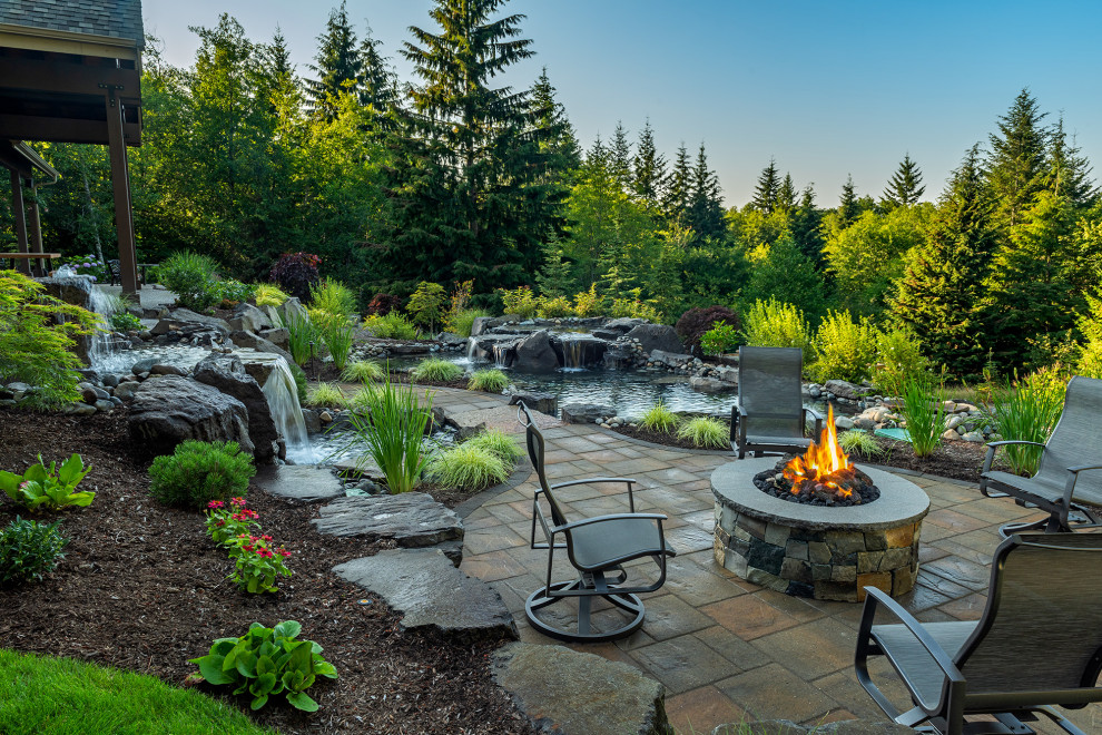 Esempio di un ampio giardino stile americano dietro casa con una cascata e pavimentazioni in pietra naturale