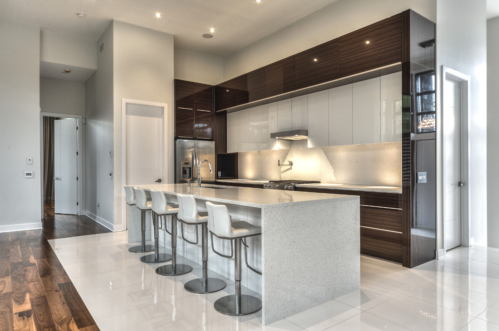 Expansive modern l-shaped kitchen in Montreal with glass-front cabinets, dark wood cabinets, quartz benchtops, stainless steel appliances and with island.