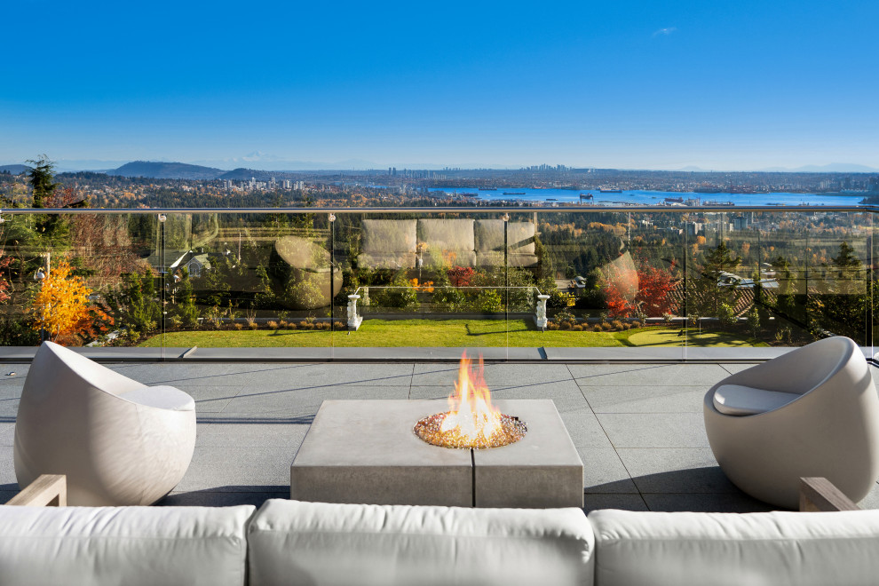 Contemporary backyard patio in Vancouver with a fire feature and no cover.
