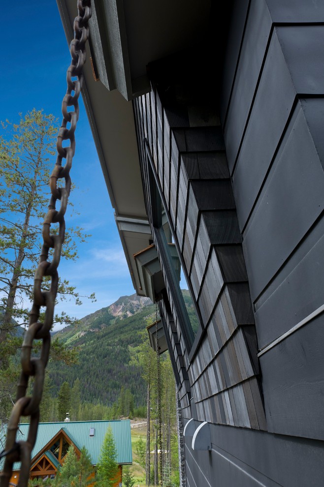 Large contemporary two-storey black house exterior in Vancouver with mixed siding, a gable roof and a shingle roof.