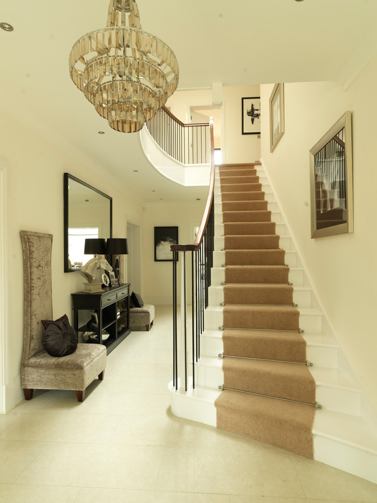 Large traditional painted wood curved staircase in Cambridgeshire with painted wood risers.