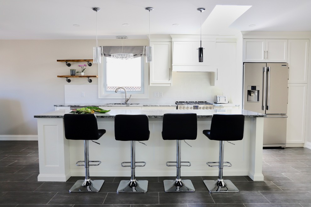 Design ideas for a mid-sized contemporary single-wall open plan kitchen in Other with an undermount sink, shaker cabinets, white cabinets, quartz benchtops, white splashback, porcelain splashback, stainless steel appliances, vinyl floors, with island, grey floor and black benchtop.