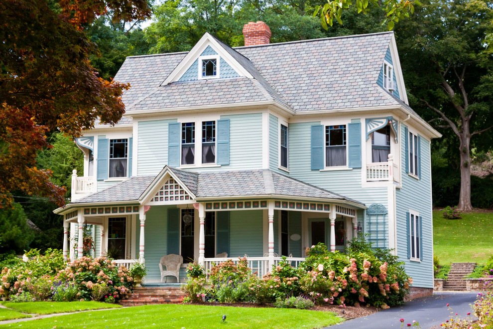 Large traditional two-storey blue house exterior in Boston with a gable roof and a shingle roof.