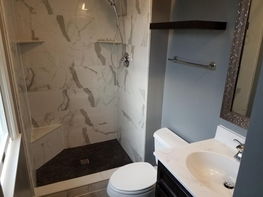 Inspiration for a mid-sized transitional 3/4 marble tile and white tile porcelain tile and beige floor alcove shower remodel with a two-piece toilet, white countertops, raised-panel cabinets, white cabinets, beige walls, an undermount sink and quartz countertops