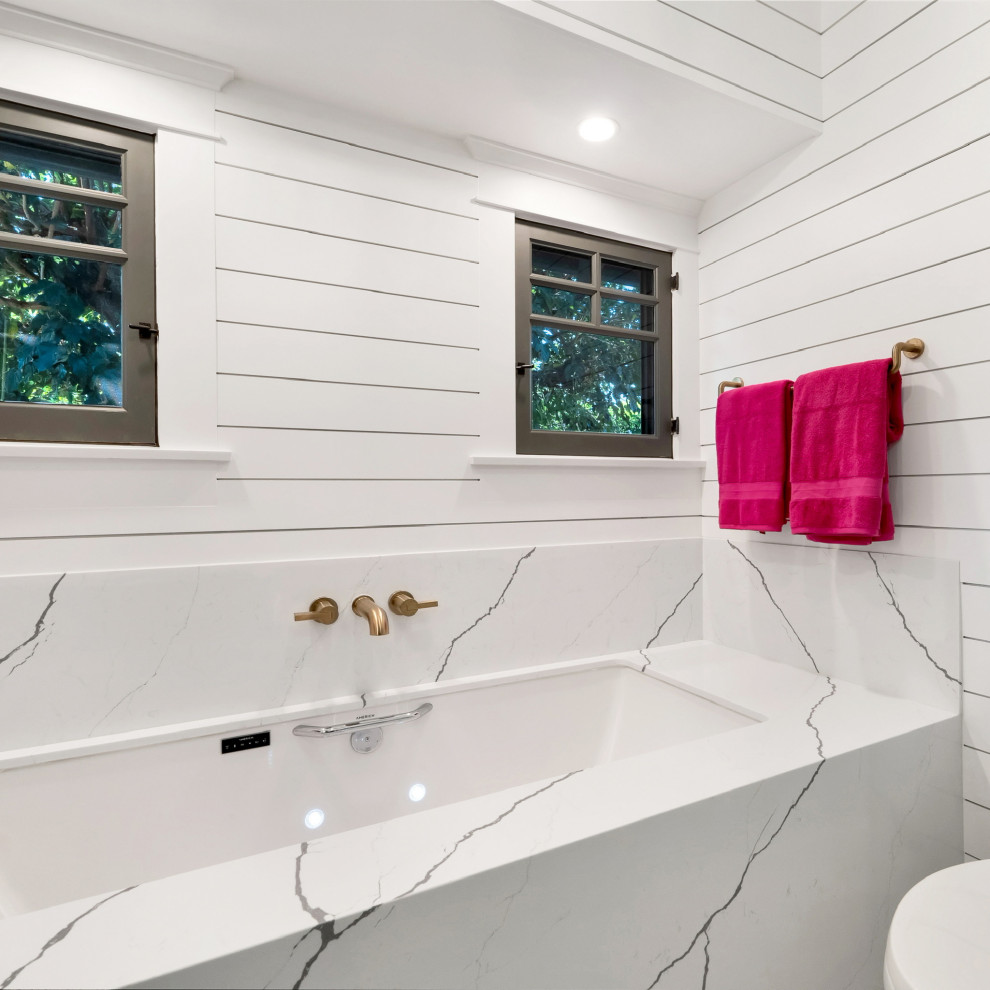 Réalisation d'une grande salle de bain principale minimaliste avec un placard à porte shaker, des portes de placard bleues, une baignoire posée, une douche d'angle, WC à poser, un carrelage blanc, un mur blanc, un sol en carrelage de céramique, un lavabo posé, un plan de toilette en quartz, un sol gris, une cabine de douche à porte battante, un plan de toilette blanc, meuble simple vasque, meuble-lavabo sur pied et du lambris.