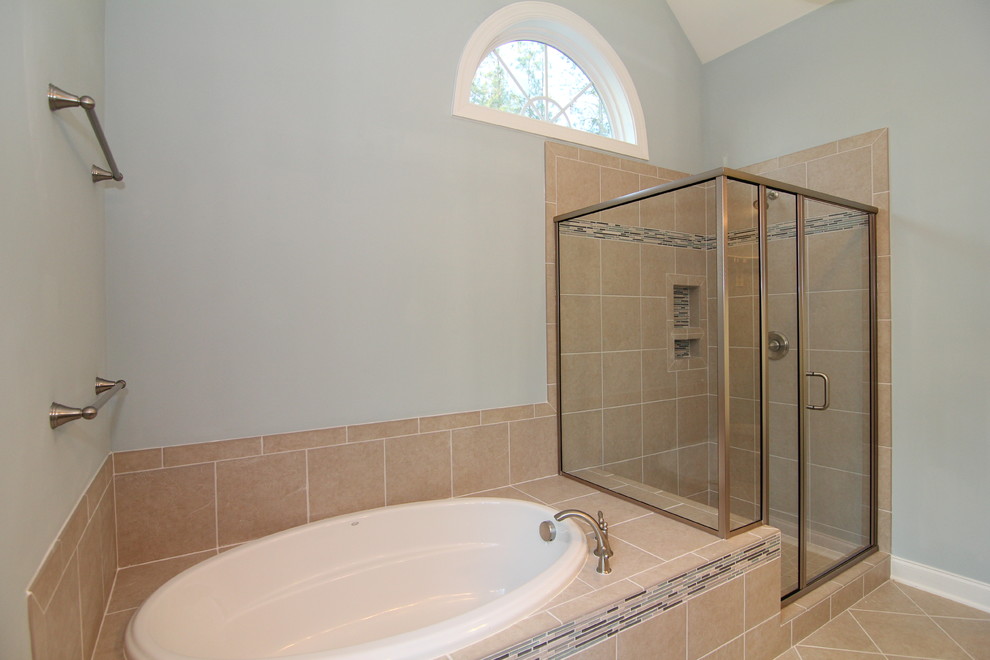 This is an example of a mid-sized traditional master bathroom in Raleigh with dark wood cabinets, a corner tub, a corner shower, a one-piece toilet, beige tile, ceramic tile, ceramic floors, an undermount sink, granite benchtops, recessed-panel cabinets and grey walls.