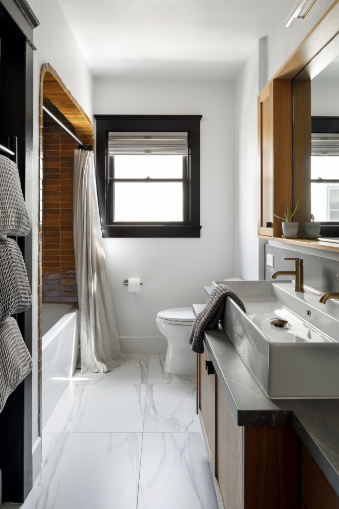 Bild på ett litet medelhavsstil grå grått badrum för barn, med skåp i shakerstil, bruna skåp, ett badkar i en alkov, en dusch/badkar-kombination, en toalettstol med hel cisternkåpa, gul kakel, perrakottakakel, vita väggar, klinkergolv i porslin, ett avlångt handfat, bänkskiva i kvarts, vitt golv och dusch med duschdraperi