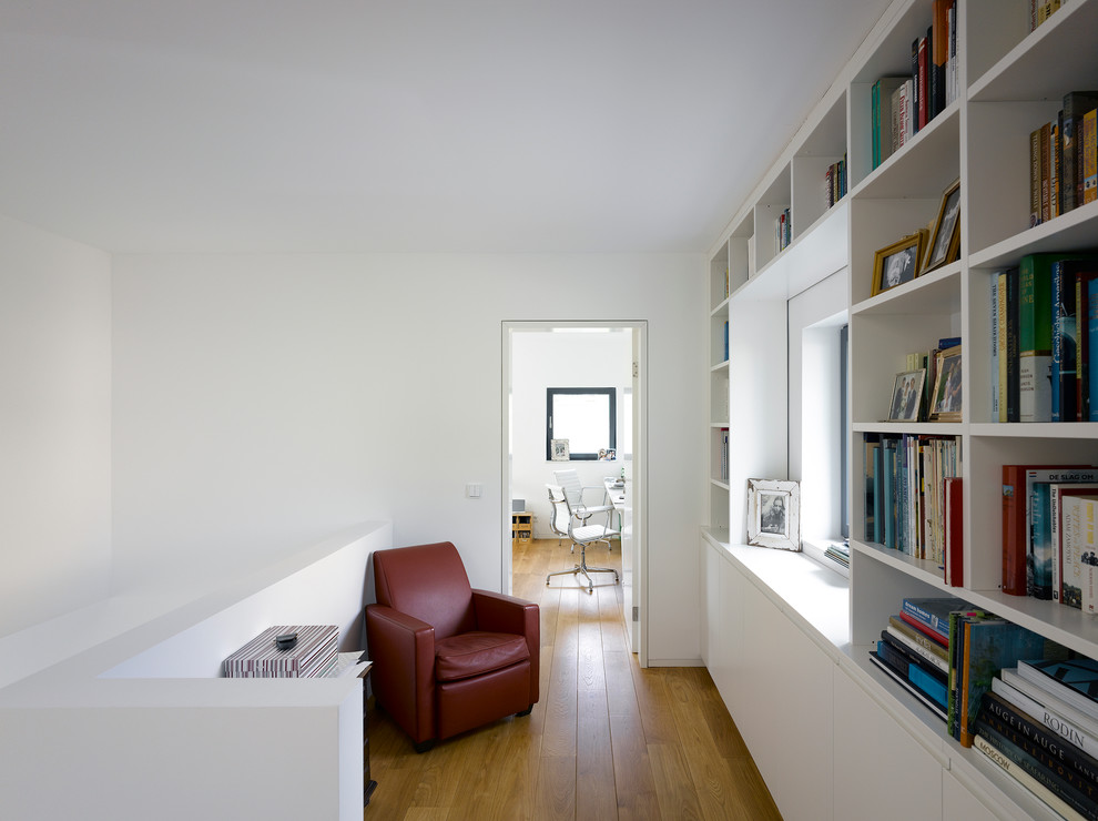 Inspiration for a mid-sized contemporary hallway in Berlin with white walls and medium hardwood floors.