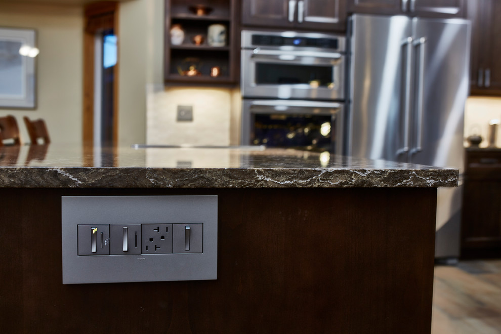 Inspiration for a mid-sized transitional u-shaped porcelain tile eat-in kitchen remodel with an undermount sink, shaker cabinets, dark wood cabinets, quartz countertops, beige backsplash, stone tile backsplash, stainless steel appliances and a peninsula