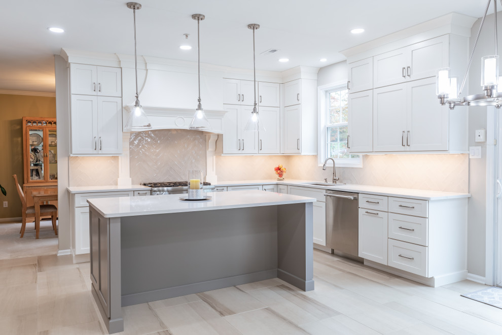 Large contemporary l-shaped open plan kitchen in Philadelphia with an undermount sink, shaker cabinets, white cabinets, quartzite benchtops, beige splashback, ceramic splashback, stainless steel appliances, porcelain floors, with island, beige floor and white benchtop.
