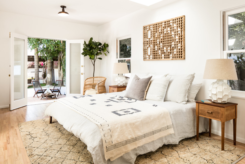 Design ideas for a mediterranean bedroom in Los Angeles with white walls, light hardwood floors and beige floor.